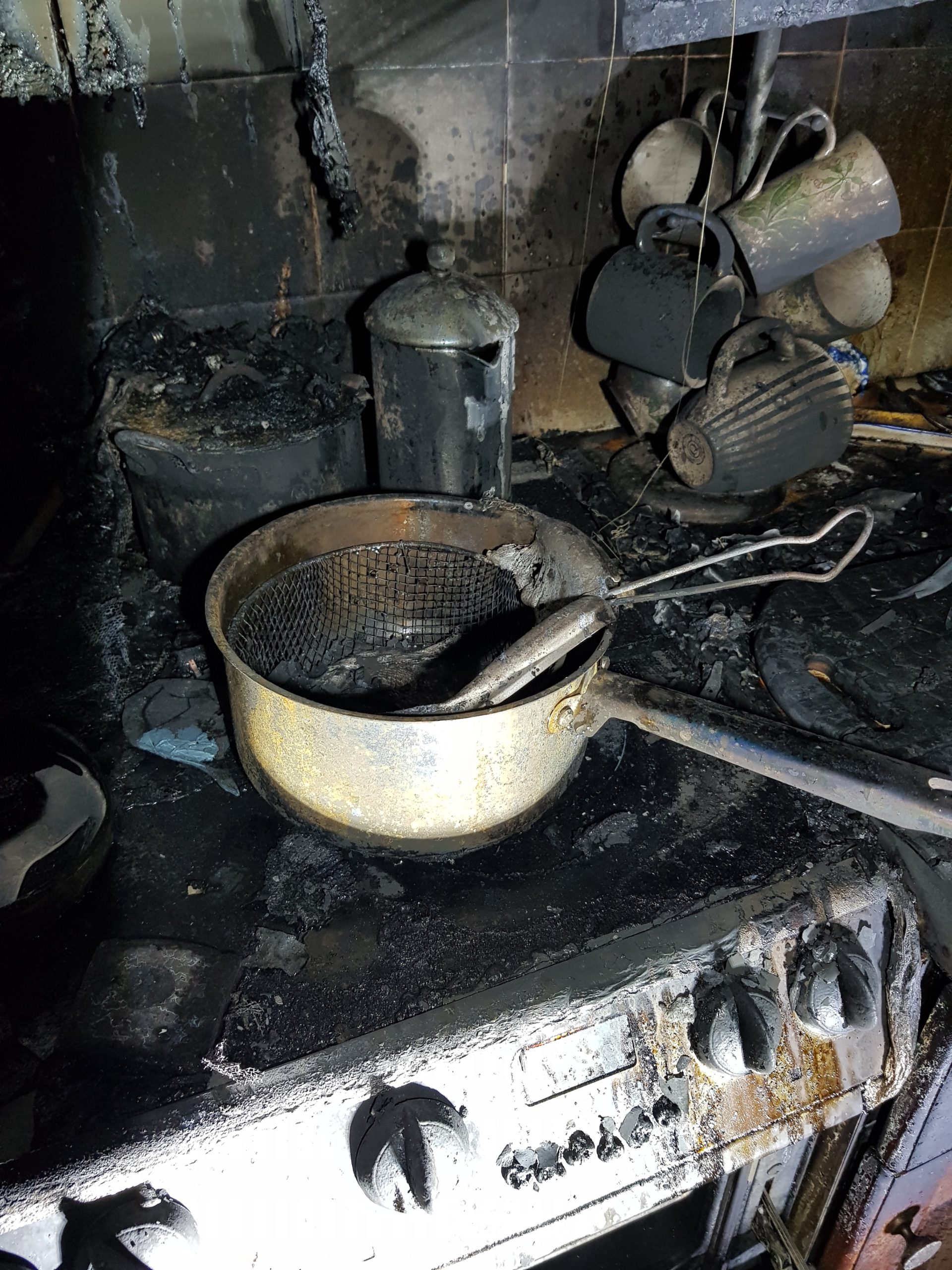 Damaged chip pan and kitchen following fire