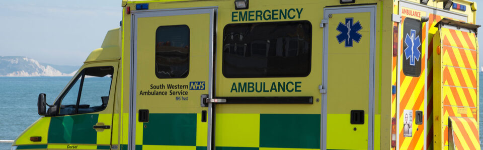 Emergency ambulance on standby at the seafront in Weymouth a seaside town in Dorset England UK